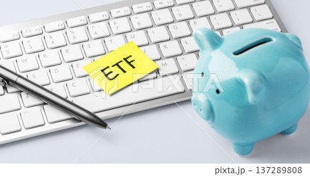 Financial planning and savings for ETF investment. Piggy bank and office supplies on desk 137289808
