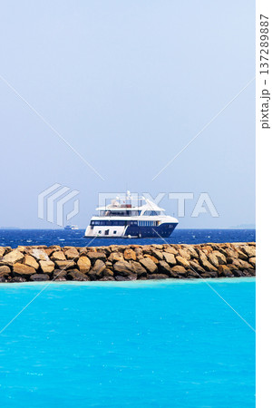 Sapphire waters glow beside a stone breakwater 137289887