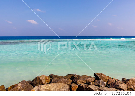 Clear turquoise water meets rugged shoreline rocks Clear turquoise water meets rugged shoreline rocks 137290104