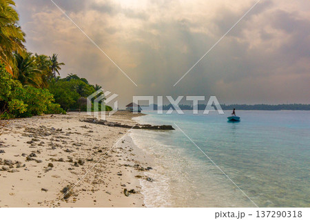 Sunlight pierces clouds above tranquil turquoise waters Sunlight pierces clouds above tranquil turquoise waters 137290318