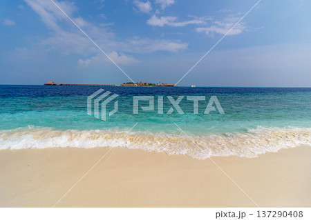 Golden sand meets turquoise waves under clear blue sky Golden sand meets turquoise waves under clear blue sky 137290408