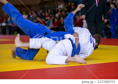 Russian judo athlete in white gi grappling Russian judo athlete in white gi grappling 137290555
