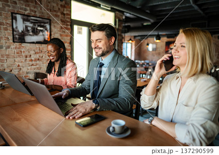 Business people collaborating while working at cafe 137290599