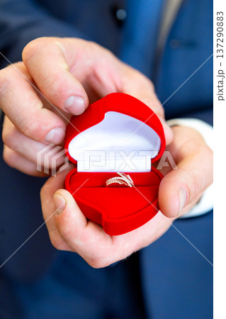 wedding rings in hand. wedding rings in the hands of the groom. wedding rings in hand. wedding rings in the hands of the groom. 137290883