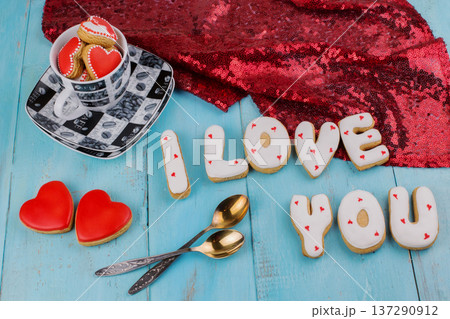 Homemade cookies in the form of a heart or I love you words on Valentine's Day on a blue board top view Homemade cookies in the form of a heart or I love you words on Valentine's Day on a blue board top view 137290912