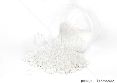 Light Powder Spills From Container Onto White Surface Creating a Soft Texture 137290982