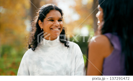 Indian woman smiling, talking with friend in park 137291472