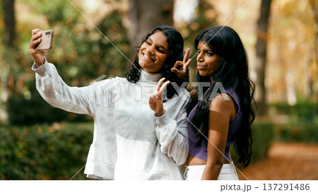 Indian women friends capturing selfie in autumn park 137291486