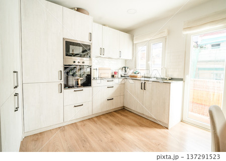 Modern kitchen interior with white cabinets and wooden floor 137291523