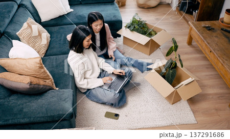 Women planning home relocation with boxes and laptop Women planning home relocation with boxes and laptop 137291686
