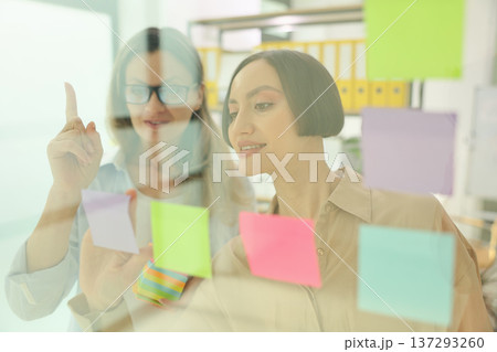 Creative brainstorming session with colorful sticky notes in a modern office 137293260