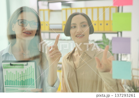 Women engage in creative brainstorming during a productive meeting in a bright office space filled with colorful notes 137293261