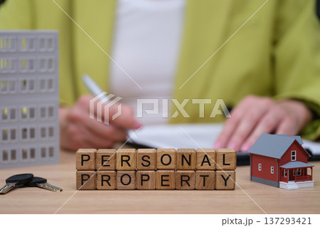 Understanding personal property in real estate transactions during a business meeting with miniature models displaying homes Understanding personal property in real estate transactions during a business meeting with miniature models displaying homes 137293421