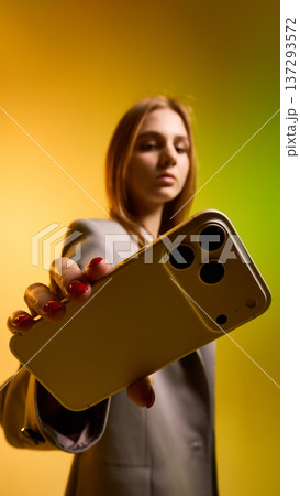 Woman holding smartphone with gradient background. Woman holding smartphone with gradient background. 137293572