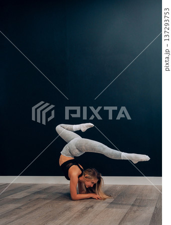 Young woman practices stretching exercise in activewear. Sport, Enjoying Fitness Training And Healthy Lifestyle Young woman practices stretching exercise in activewear. Sport, Enjoying Fitness Training And Healthy Lifestyle 137293753