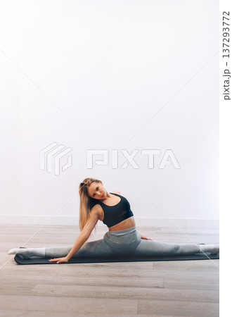 Woman Stretches Her Body While Practicing Yoga In Activewear At Home For Fitness.  Girl Stretching, Enjoying Fitness Training Yoga And Healthy Lifestyle 137293772