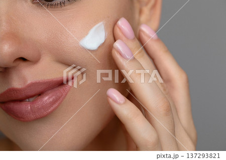 Woman with beautiful face touching healthy facial skin portrait. Beauty close up girl is applying a skincare cream. Hydration Woman with beautiful face touching healthy facial skin portrait. Beauty close up girl is applying a skincare cream. Hydration 137293821