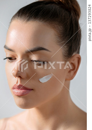 Young beautiful woman model posing with smear cream on her face Hydration. Moisturizing. 137293824