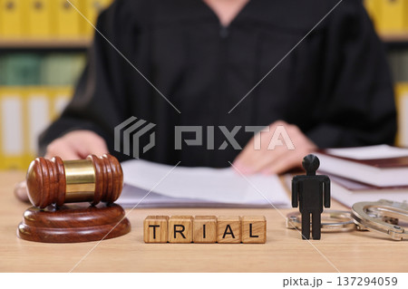 Courtroom scene highlights the tension of a trial as a judge prepares to make a ruling surrounded by legal symbols and documents Courtroom scene highlights the tension of a trial as a judge prepares to make a ruling surrounded by legal symbols and documents 137294059