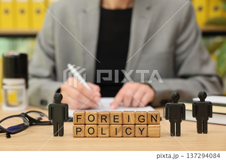 Engaging discussion on foreign policy with wooden blocks and a written notebook backdrop 137294084