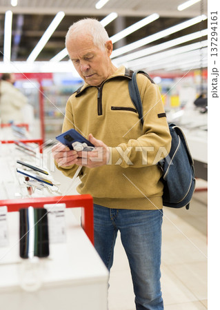 senor man pensioner buying modern tablet digital in showroom of digital electronic goods store senor man pensioner buying modern tablet digital in showroom of digital electronic goods store 137294161