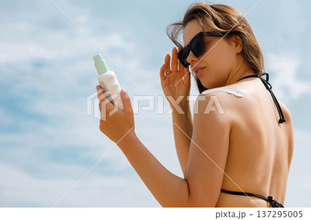 Smiling Woman Using Suncream Sunscreen Lotion in Sunlight Smiling Woman Using Suncream Sunscreen Lotion in Sunlight 137295005
