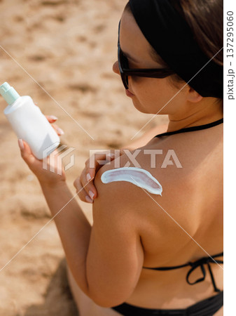 Back View Woman Applying Suncream Sunscreen Lotion on Shoulder Back View Woman Applying Suncream Sunscreen Lotion on Shoulder 137295060