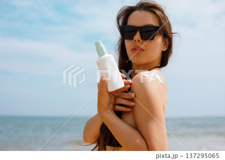 Tanned Woman Applying Suncream Sunscreen Lotion on Shoulder 137295065