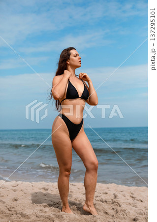 Fit young woman enjoying sunlight on beach in bikini touching neck and using sunscreen suncream lotion for UV protection skincare and summer body care routine Fit young woman enjoying sunlight on beach in bikini touching neck and using sunscreen suncream lotion for UV protection skincare and summer body care routine 137295101