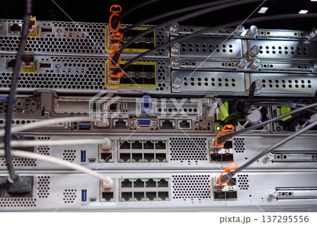 Server rack with network switches and connected fiber and ethernet cables in a data center hardware setup Server rack with network switches and connected fiber and ethernet cables in a data center hardware setup 137295556