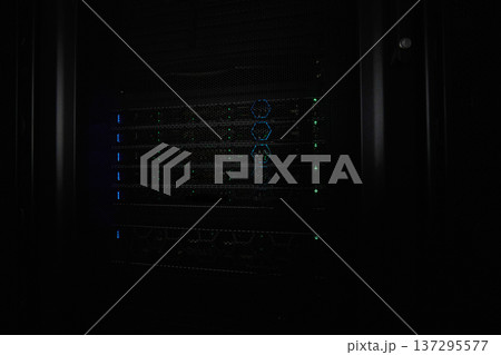 Server rack with illuminated network hardware and blinking LEDs in a dark data center 137295577