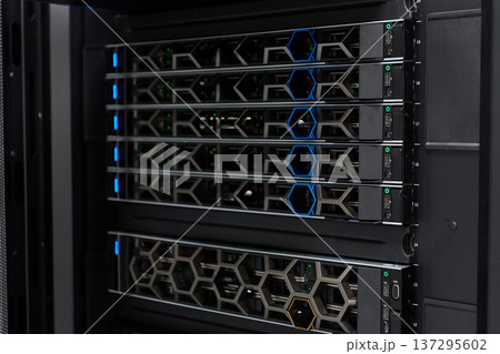 High-density server rack in a data center with modern network equipment and blue status lights High-density server rack in a data center with modern network equipment and blue status lights 137295602