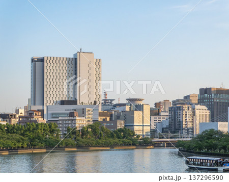 川沿いにそびえ立つ都会のビル群と遊覧船 137296590