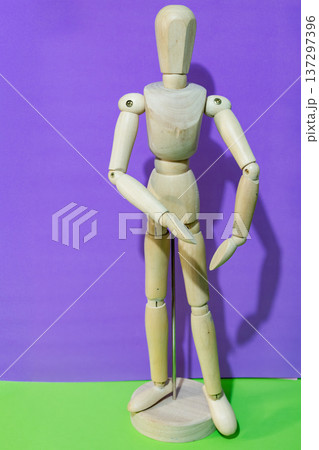 Vertical picture of a wooden mannequin figure posing isolated on a colorful background 137297396