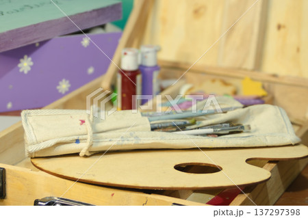 Art supplies including brushes, a palette and paints in an art set. Art supplies including brushes, a palette and paints in an art set. 137297398