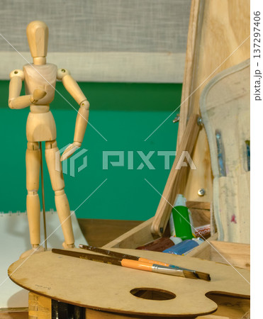 A wooden mannequin stands in an art studio as part of a drawing concept. A wooden mannequin stands in an art studio as part of a drawing concept. 137297406