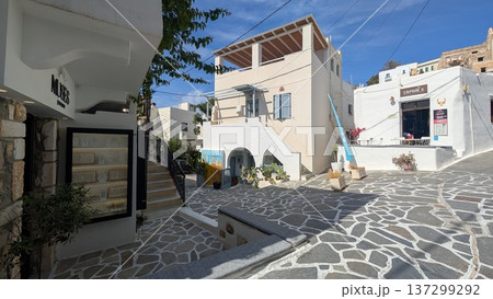 Cobblestone shopping area with white building shops and restaurants under the blue sky Cobblestone shopping area with white building shops and restaurants under the blue sky 137299292