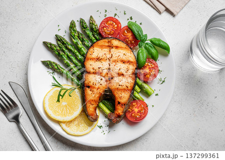 Grilled salmon steak with green asparagus, tomatoes and lemon slices Grilled salmon steak with green asparagus, tomatoes and lemon slices 137299361