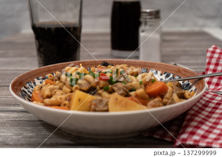 Bowl of beef stew with pasta and vegetables 137299999