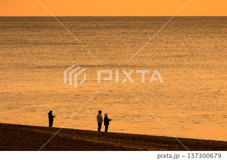 太陽に照らされ輝く海と釣り人のシルエット 太陽に照らされ輝く海と釣り人のシルエット 137300679