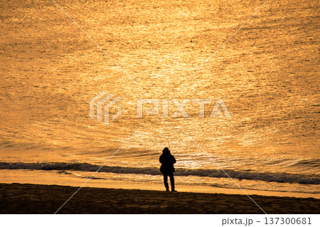 太陽に照らされ輝く海と釣り人のシルエット 太陽に照らされ輝く海と釣り人のシルエット 137300681