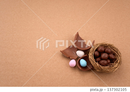 Chocolate easter eggs and nest with candy on brown background 137302105