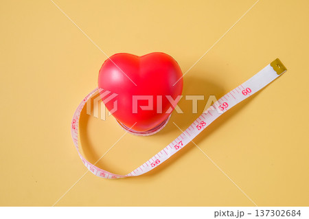 Red heart ball on measuring tape. 137302684