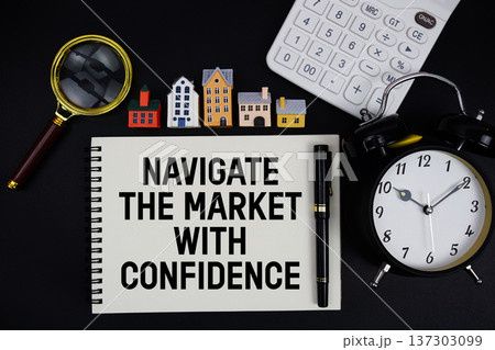Notepad with the phrase "Navigate The Market With Confidence" surrounded by a pen, calculator, magnifying glass, clock, and house model 137303099