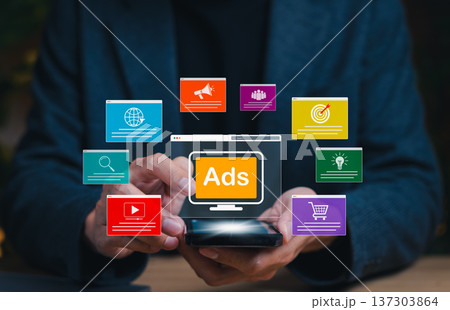 Digital advertising concept, businessman holding smartphone with online ads interface representing marketing campaign, social media promotion, target audience strategy and ecommerce growth. 137303864