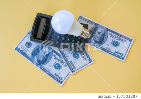 A calculator with light bulb and banknote on background, Energy saving concept. 137303887