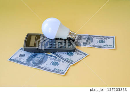 A calculator with light bulb and banknote on background, Energy saving concept. 137303888