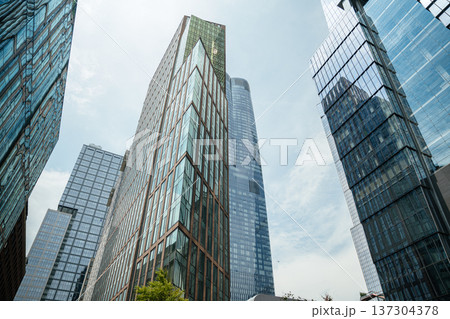 Tall modern glass towers rising into the sky in Manhattan, New York City. Contemporary skyscrapers define the urban skyline and architectural landscape. 137304378