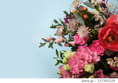 Floral bouquet with pink roses, astrantia, and carnations on blue background. Copy space for greetings, invitations, or spring promotions. 137305524
