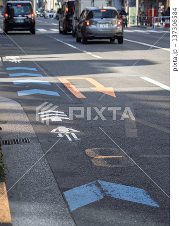 車道の左端に設置された自転車ナビマーク（白色）と自転車ナビライン（青色） 137306584